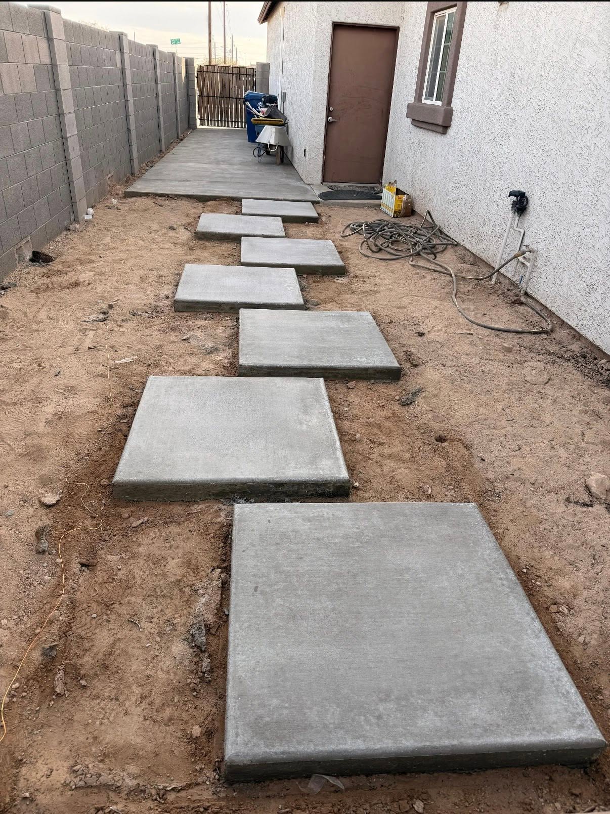 Poured concrete stepping pads in a side-yard walkway