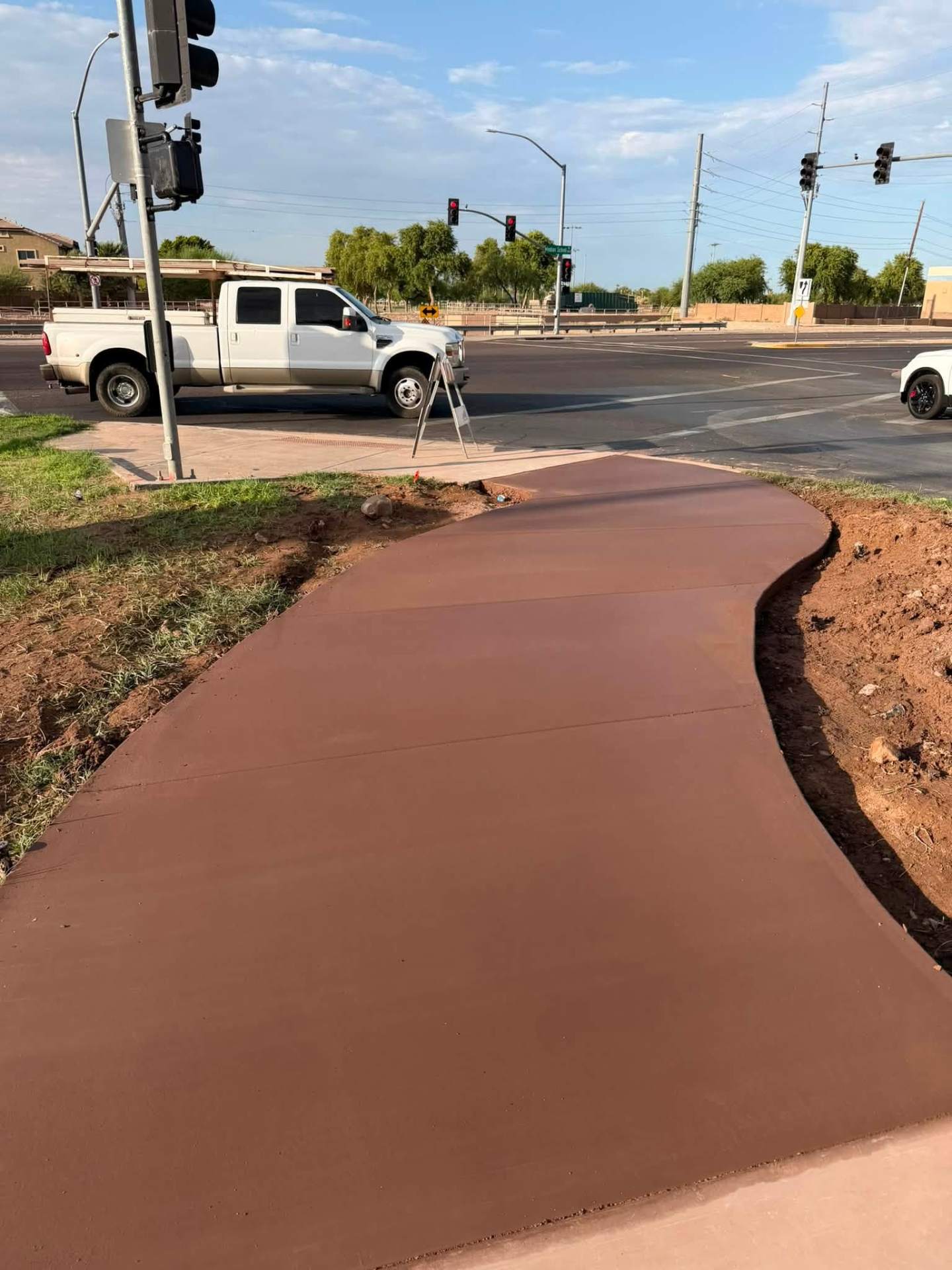 Colored curved concrete walkway near an intersection
