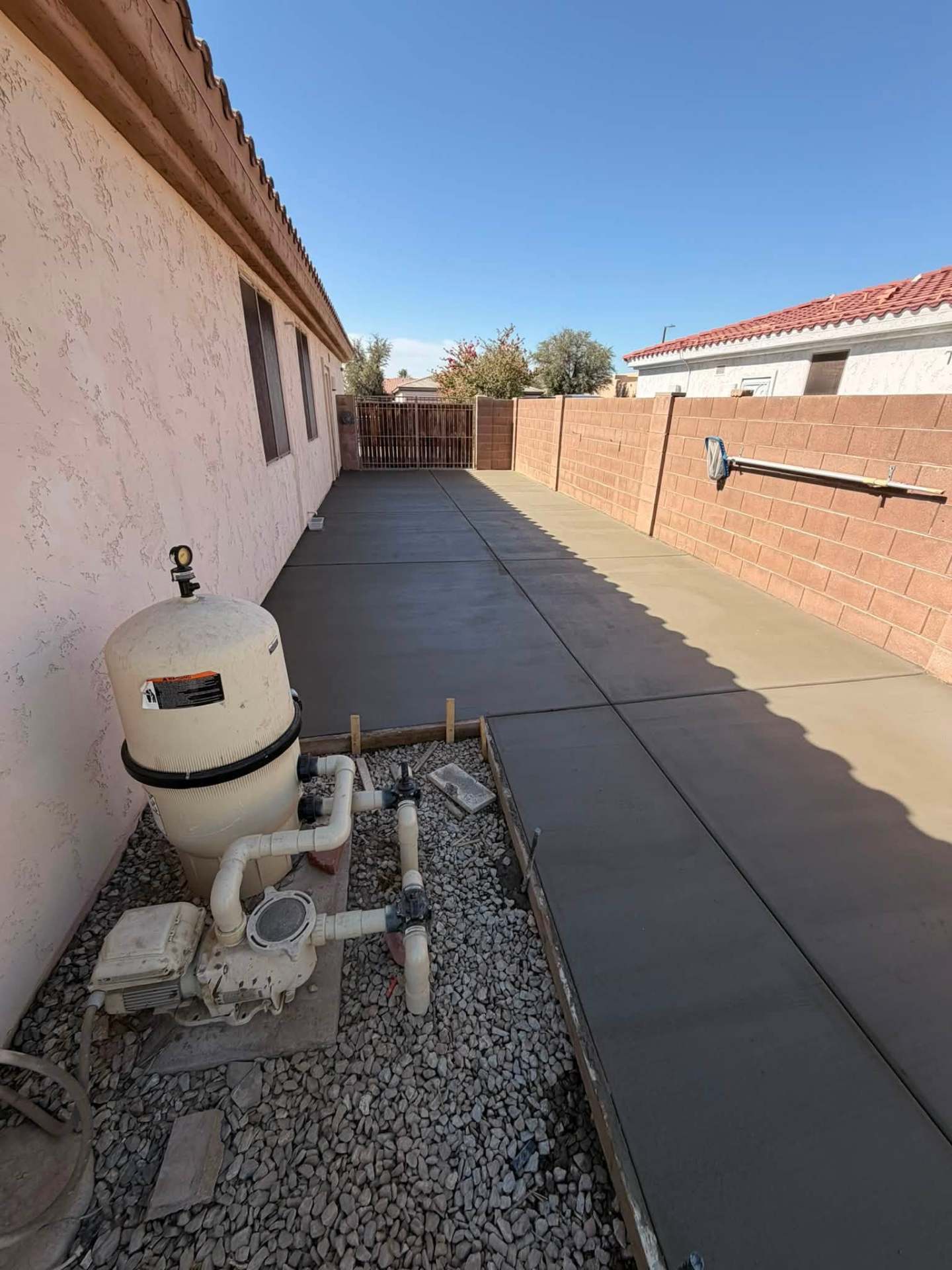 Finished side-yard concrete pad next to a home
